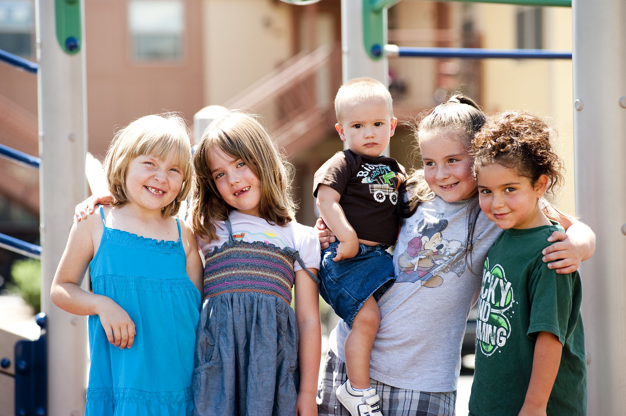 photo of kids posing in front of playground at villas on the bluff, delta colorado