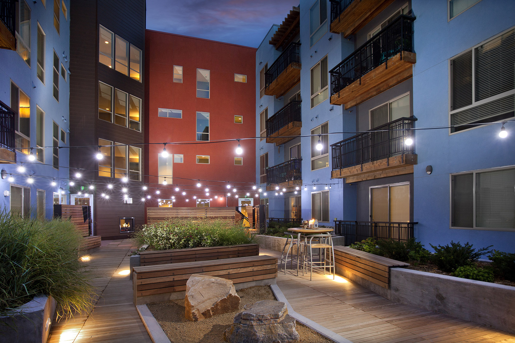 Apartment balconies overlooking Courtyard with festoon lights, benches, planters, boulders and seating