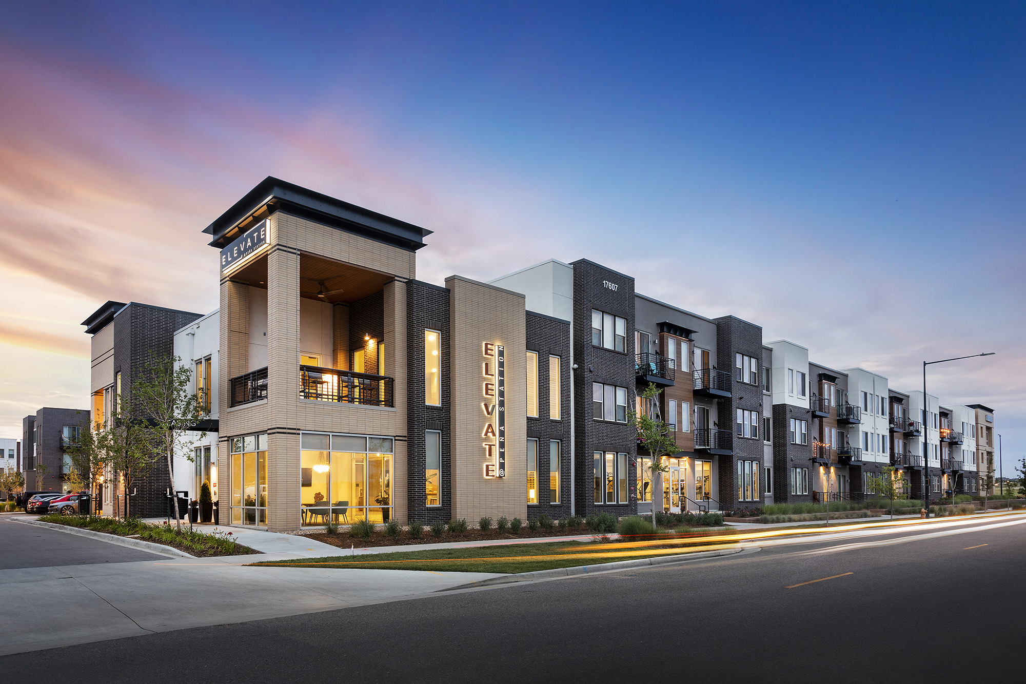 Corner view at dusk of Elevate at Pena Station 3 storey apartments with Signage