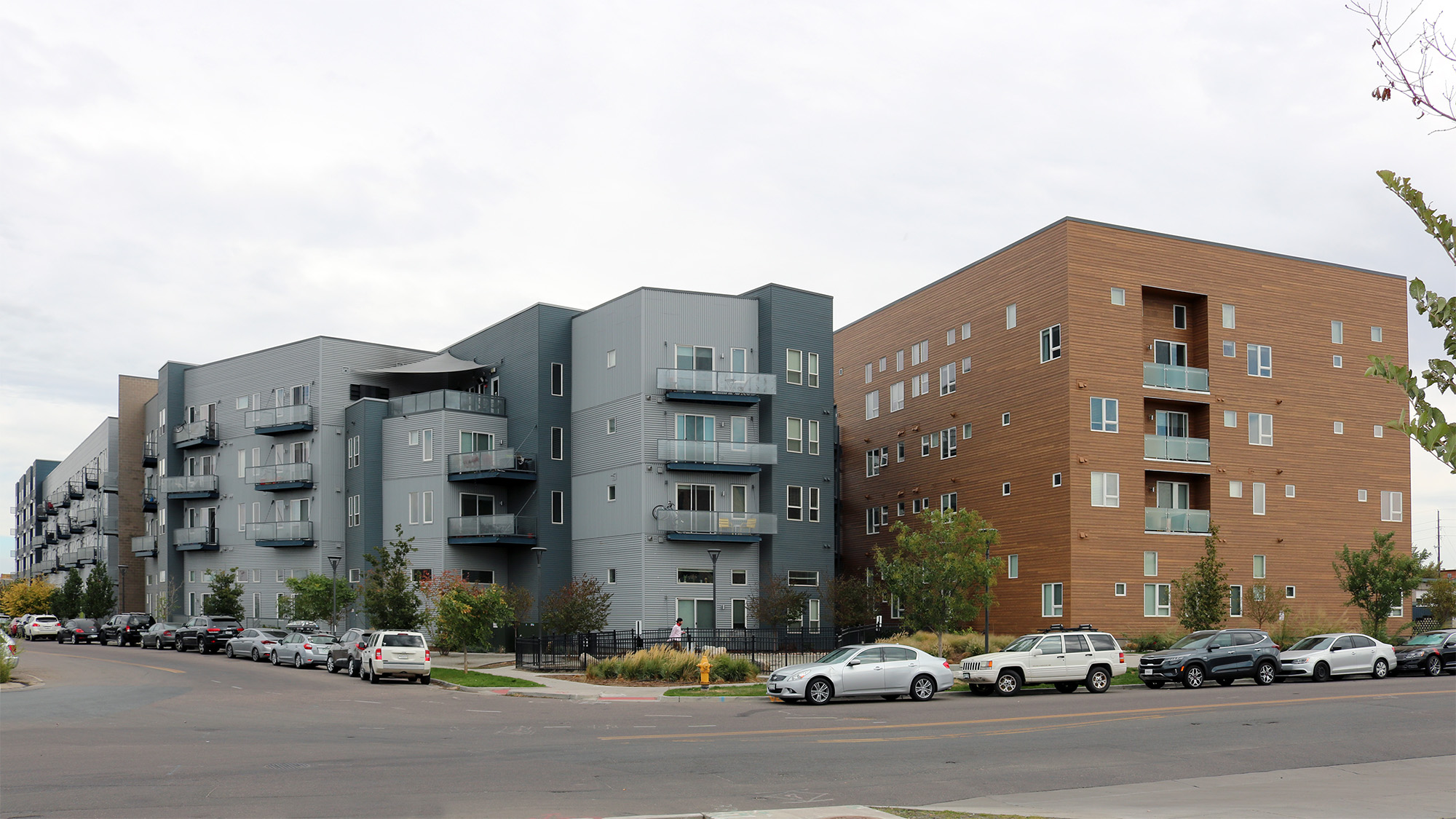 Exterior view of Dylan apartments with dog park in foreground