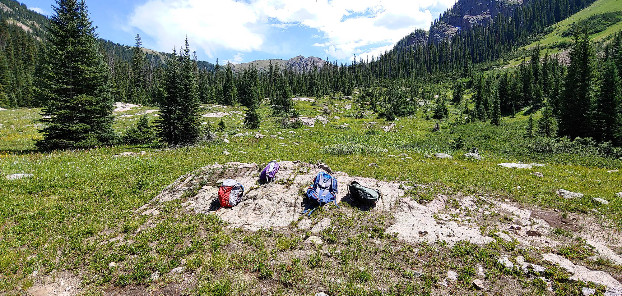 Backpacks on a rocky outcropping in a mountain landscape