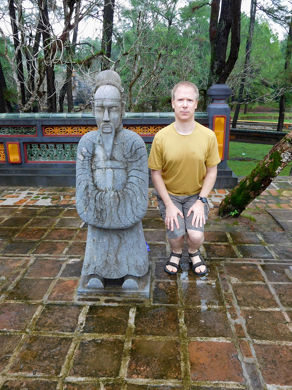 Alan posing next to sculpture of a warrior at hue tombs vietnam